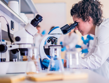 researcher peering into a microscope