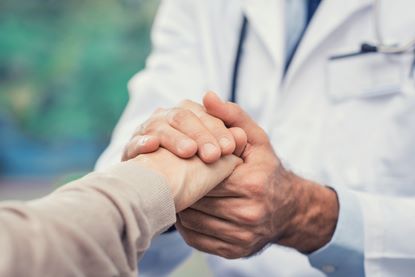 Doctor holding patients hand