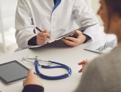 Doctor reviewing notes on clipboard