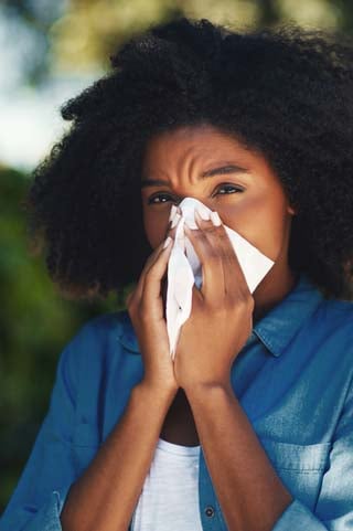 Woman blowing her nose with tissue