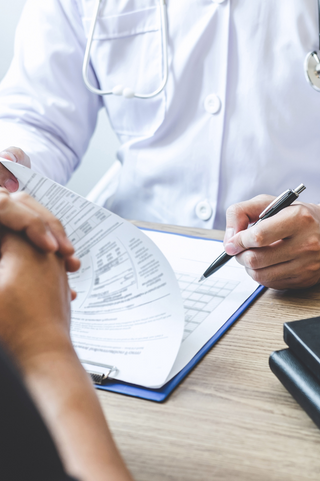 healthcare professional filling out patient information on a clipboard